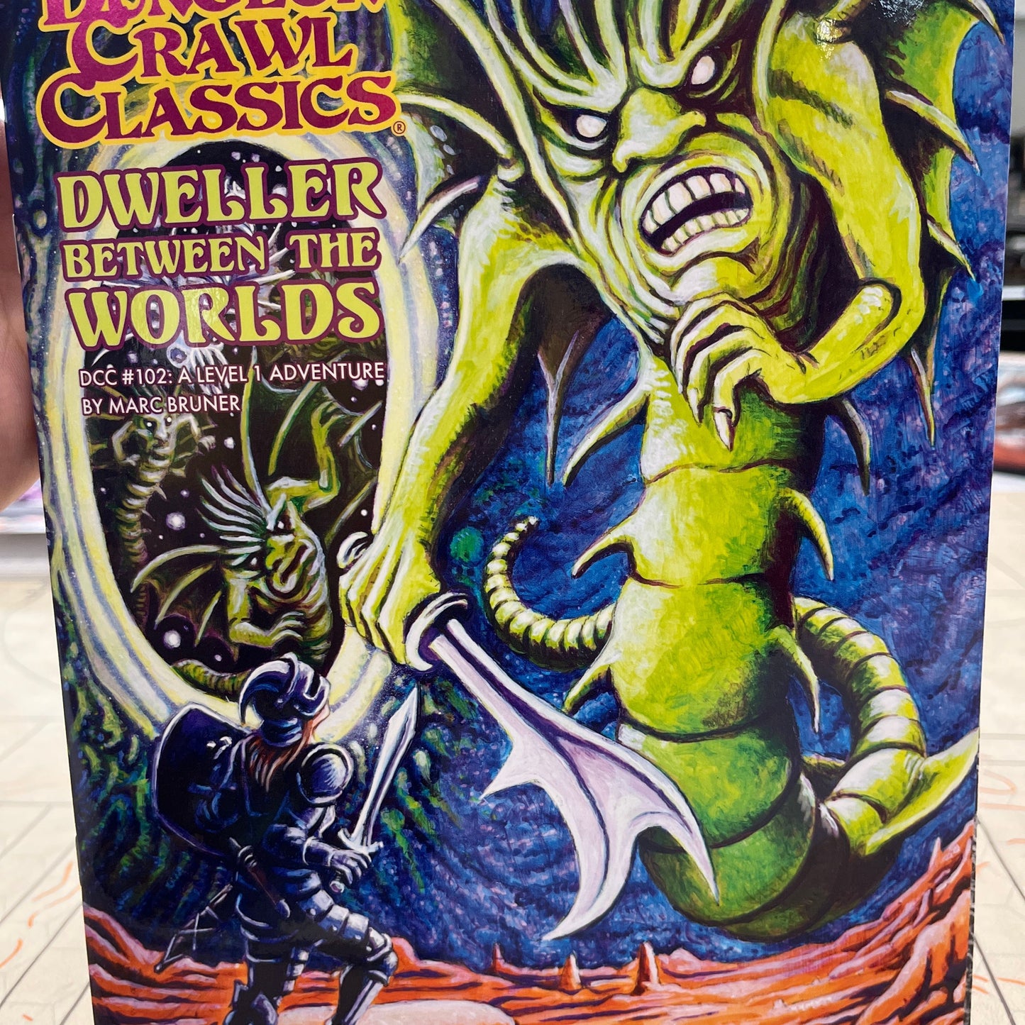 Book cover of "Dweller Between the Worlds" RPG by Goodman Games, featuring dark fantasy artwork and title text.