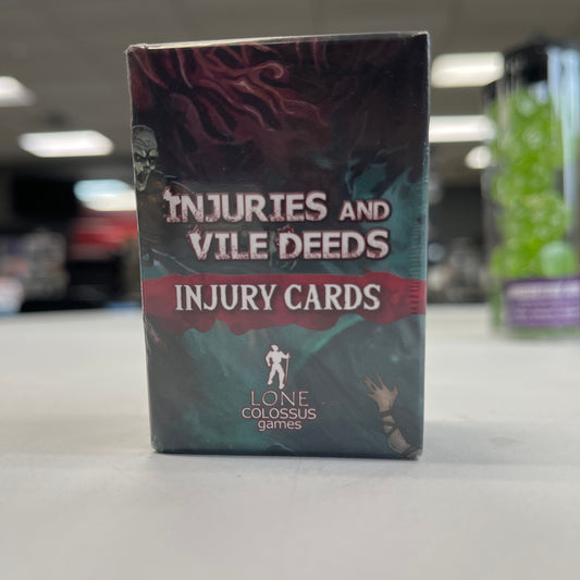 Injuries and Vile Deeds injury cards from TCB Games & Collectibles laid out on a surface, showing detailed artwork and card titles.